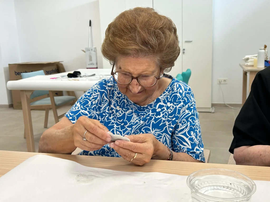 persona mayor utilizando arcilla en el taller