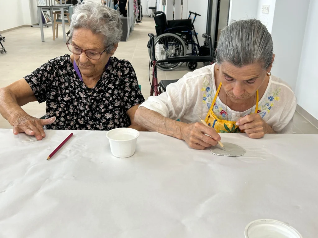 residentes participando en el taller de arcilla